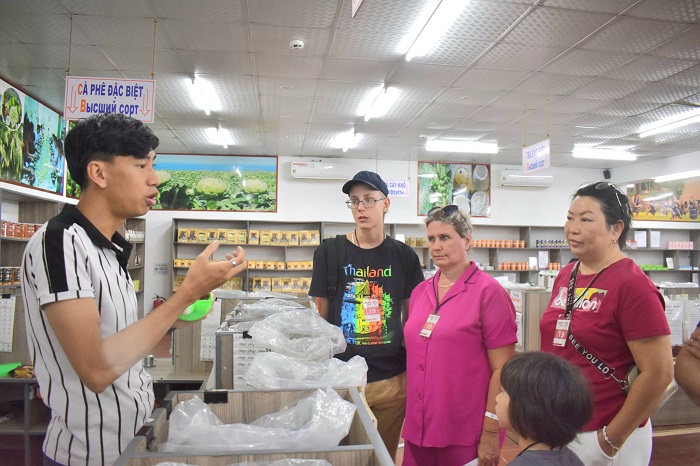 Du khách được nhân viên bán hàng tư vấn về hàng lưu niệm khi đến du lịch Nha Trang - Khánh Hòa